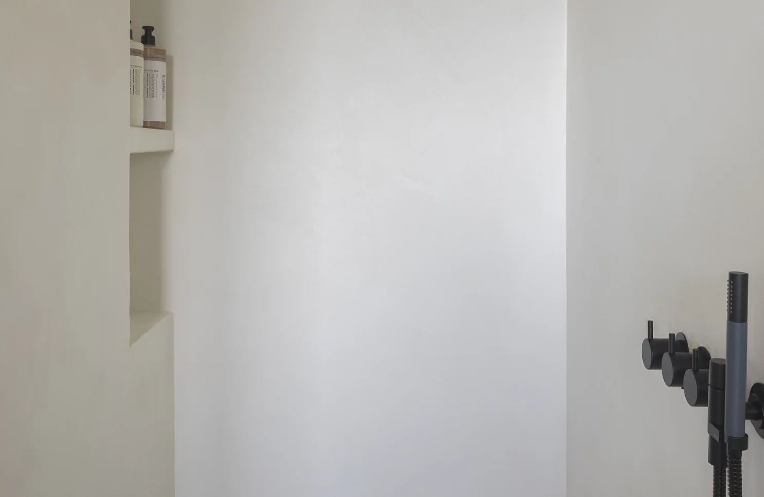 Tijdloze badkamer met witte wanden en zwart designkraanwerk in Meer